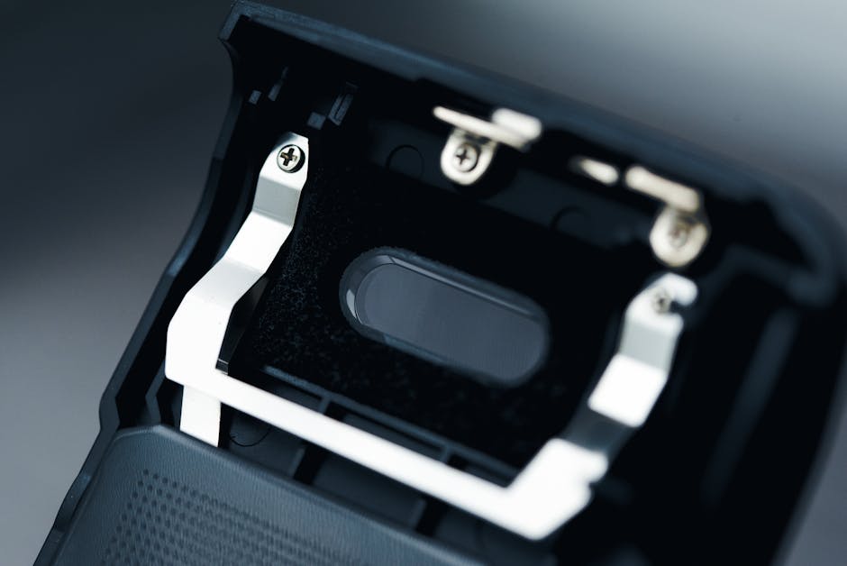 Detailed view of an internal electronic component with screws and metallic parts.